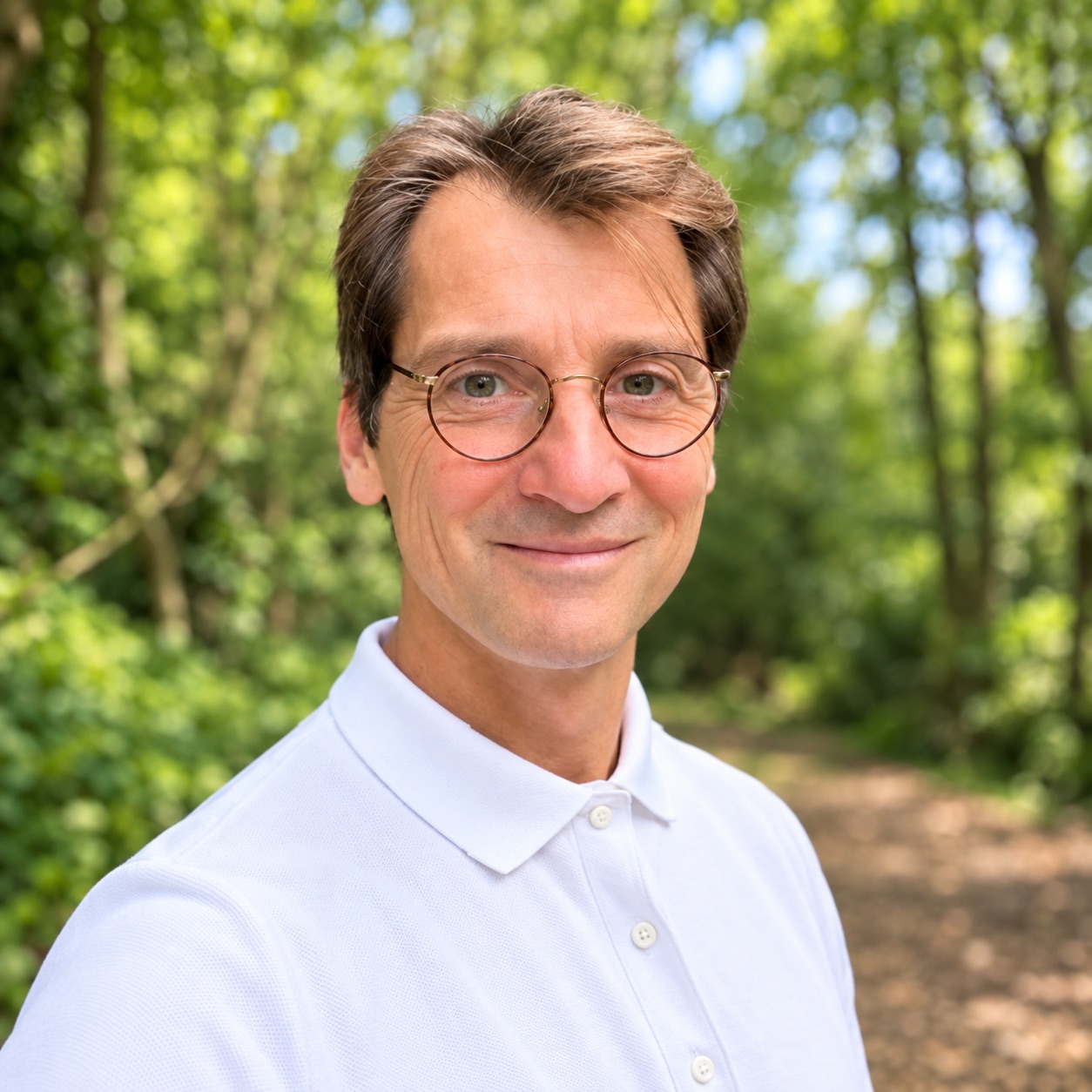 Portrait d’Adrien Tingry dans un environnement naturel, devant des arbres.
